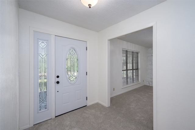 carpeted entryway featuring a textured ceiling