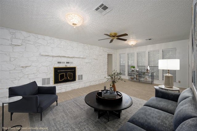 1498 Riley Rd, Whitesboro, TX 76273 - living room with ceiling fan, a textured ceiling, and a fireplace