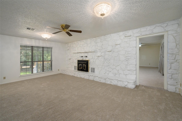 1498 Riley Rd, Whitesboro, TX 76273 - unfurnished living room featuring ceiling fan, carpet flooring, a stone fireplace, and a textured ceiling