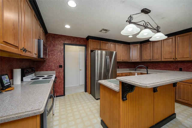 kitchen featuring an island with sink, appliances with stainless steel finishes, a kitchen bar, and decorative light fixtures