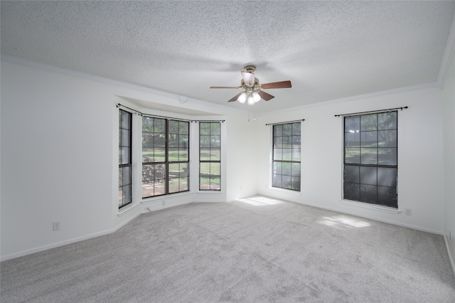 carpeted spare room featuring a textured ceiling, crown molding, and ceiling fan