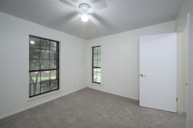 carpeted empty room featuring ceiling fan and a textured ceiling