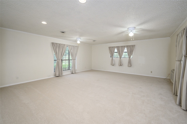 carpeted spare room with ornamental molding, a textured ceiling, and ceiling fan