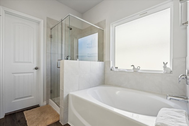 bathroom with independent shower and bath and hardwood / wood-style flooring