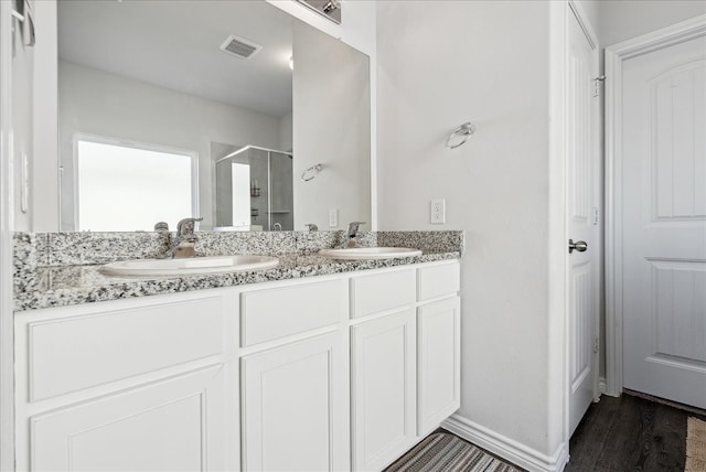 bathroom featuring vanity, hardwood / wood-style floors, and a shower with shower door