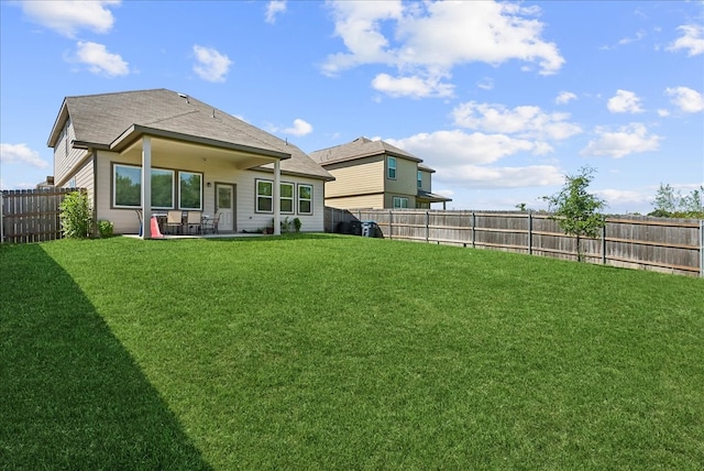 rear view of property featuring a lawn and a patio