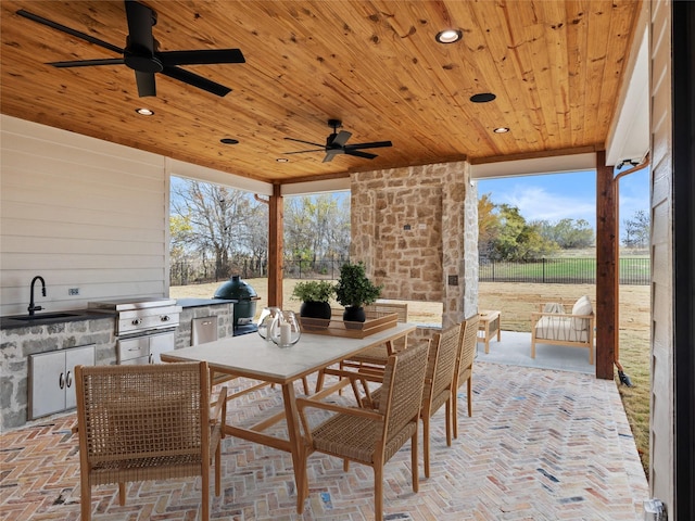 view of patio with ceiling fan, area for grilling, sink, and grilling area