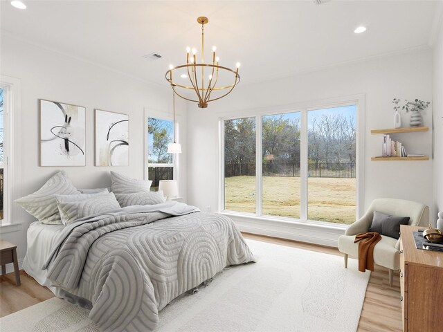 bedroom featuring light hardwood / wood-style flooring, a chandelier, and ornamental molding