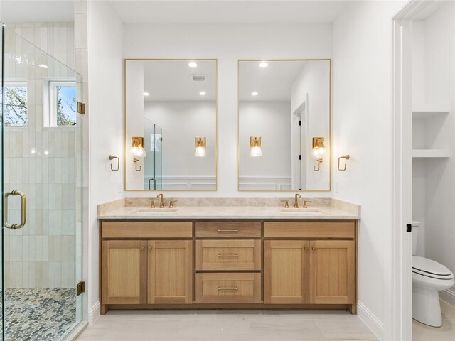 bathroom featuring tile patterned flooring, vanity, toilet, and an enclosed shower