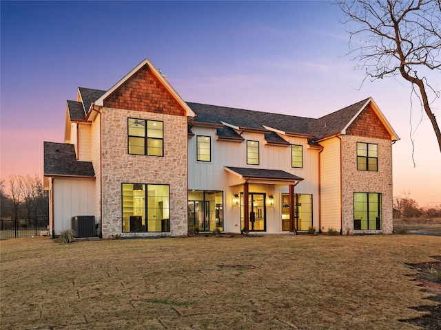 view of front of property with a lawn and cooling unit