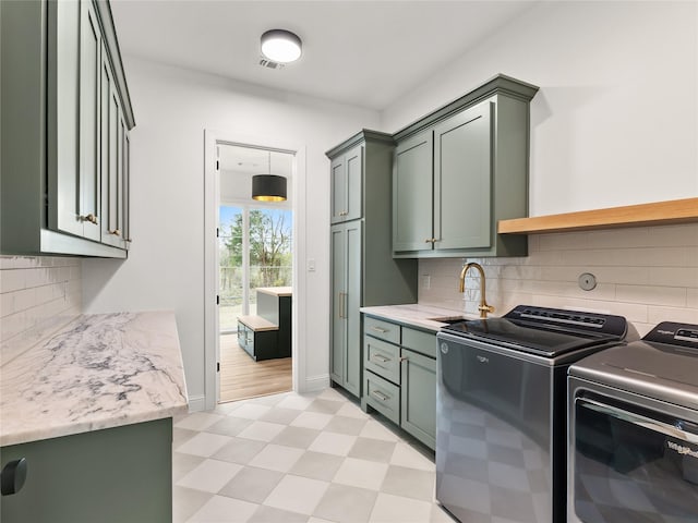 washroom featuring cabinets, washing machine and clothes dryer, and sink