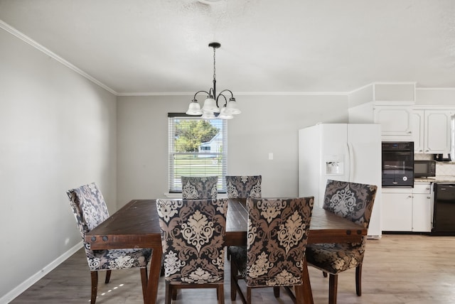 dining room with an inviting chandelier, crown molding, and light hardwood / wood-style floors