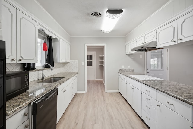 kitchen featuring white cabinets, black appliances, dark stone countertops, and sink