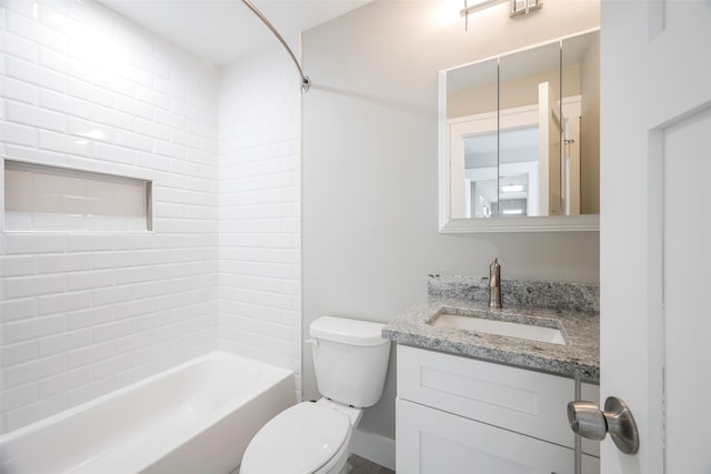 full bathroom featuring vanity, tiled shower / bath combo, and toilet