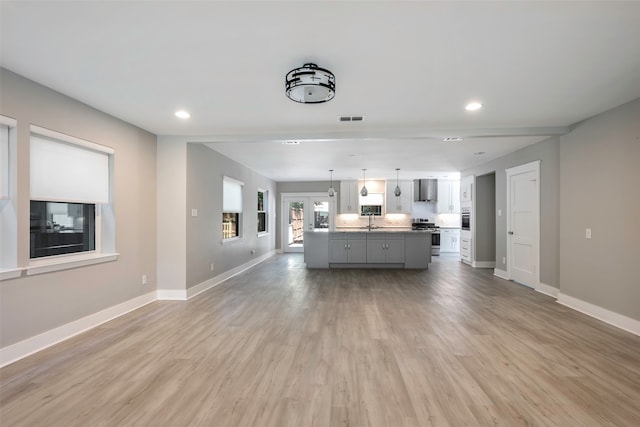 unfurnished living room with hardwood / wood-style flooring and sink