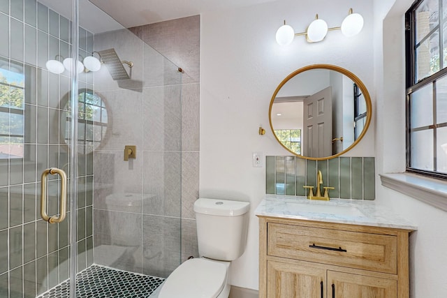 bathroom with an enclosed shower, vanity, and toilet