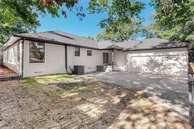 back of property featuring cooling unit and a garage