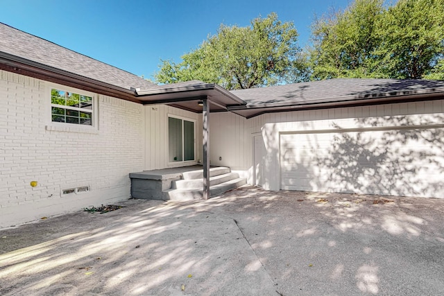 exterior space featuring roof with shingles, concrete driveway, an attached garage, crawl space, and brick siding