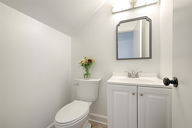 bathroom with vanity, lofted ceiling, a textured ceiling, tile patterned floors, and toilet