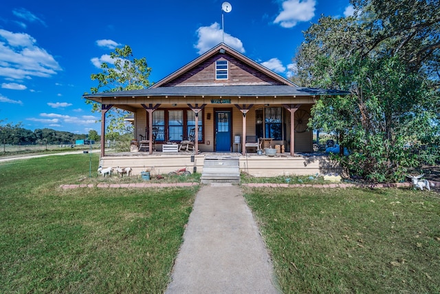 view of front facade with a front yard and covered porch