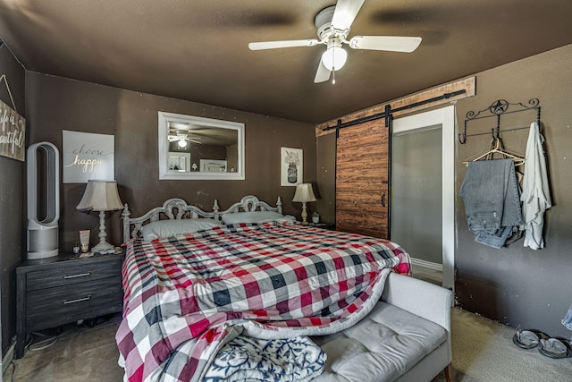 carpeted bedroom with ceiling fan and a barn door