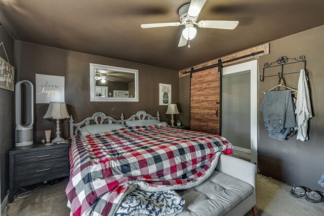 carpeted bedroom with a ceiling fan and a barn door