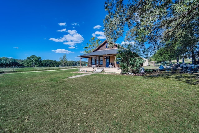 rear view of house featuring a porch and a lawn