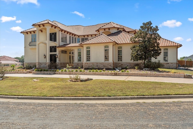 mediterranean / spanish home with a front lawn