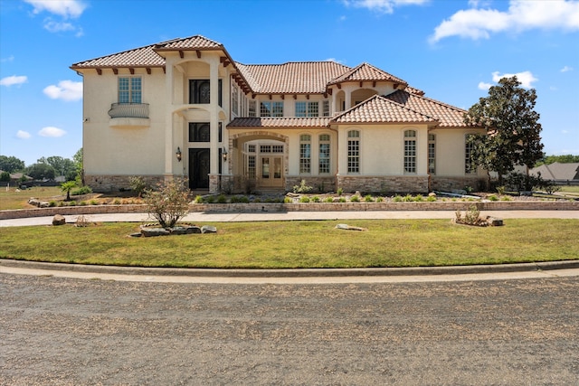 mediterranean / spanish-style house featuring a balcony and a front yard