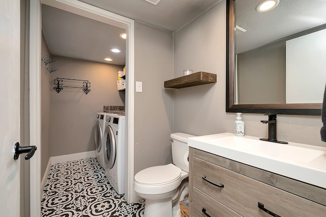 bathroom with washing machine and dryer, vanity, toilet, and tile patterned flooring