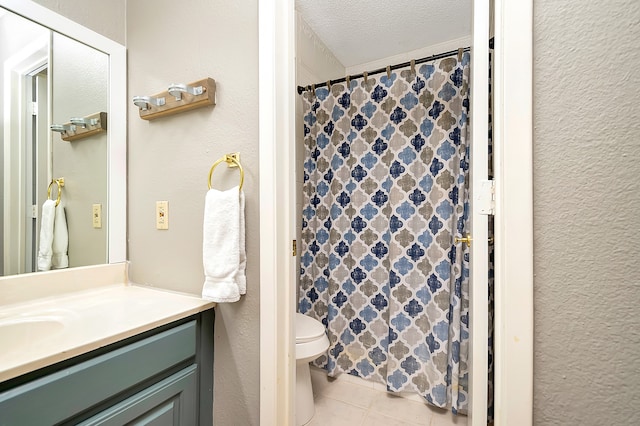 bathroom featuring tile patterned flooring, a textured ceiling, a shower with curtain, vanity, and toilet