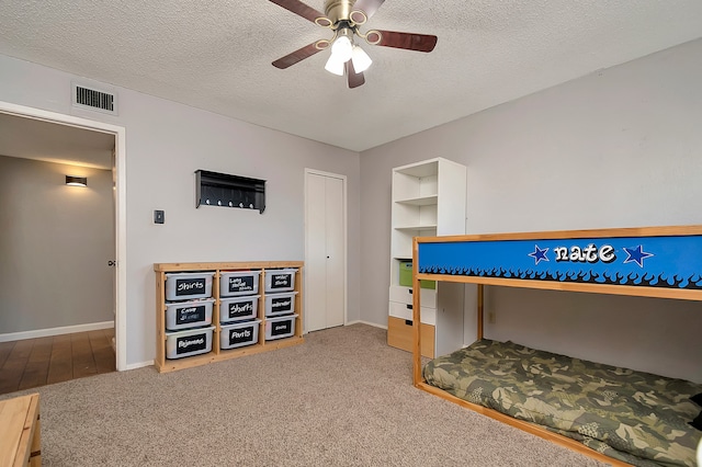 carpeted bedroom featuring a textured ceiling and ceiling fan