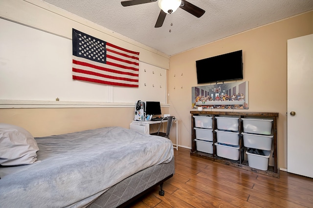 bedroom with ceiling fan, a textured ceiling, and dark wood-type flooring