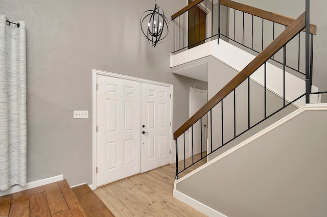 foyer with light hardwood / wood-style flooring and an inviting chandelier