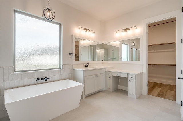 bathroom featuring vanity, tile patterned floors, a bathtub, and tile walls