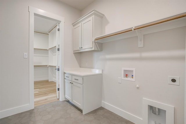 washroom with electric dryer hookup, cabinets, gas dryer hookup, light tile patterned floors, and hookup for a washing machine