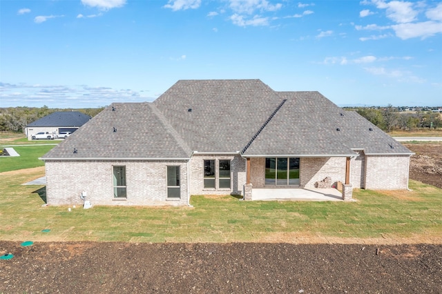 back of property featuring a yard and a patio