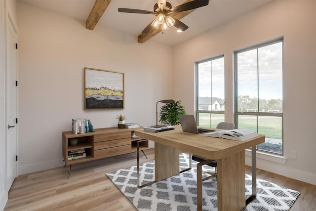 home office featuring a wealth of natural light, ceiling fan, beam ceiling, and light wood-type flooring