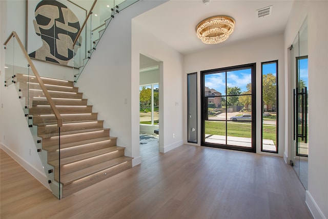 foyer entrance with a notable chandelier and hardwood / wood-style floors