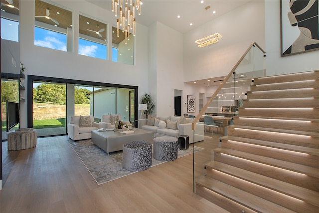 living room featuring a notable chandelier, hardwood / wood-style floors, and a high ceiling