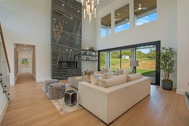 living room with hardwood / wood-style floors, a tiled fireplace, and a high ceiling