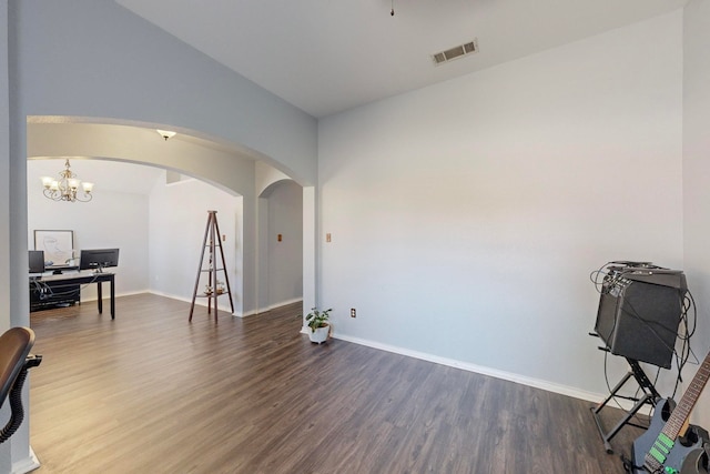 interior space with an inviting chandelier, vaulted ceiling, and dark hardwood / wood-style floors