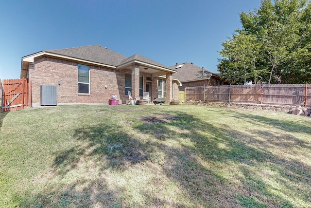 back of property with a yard, central air condition unit, and a patio area