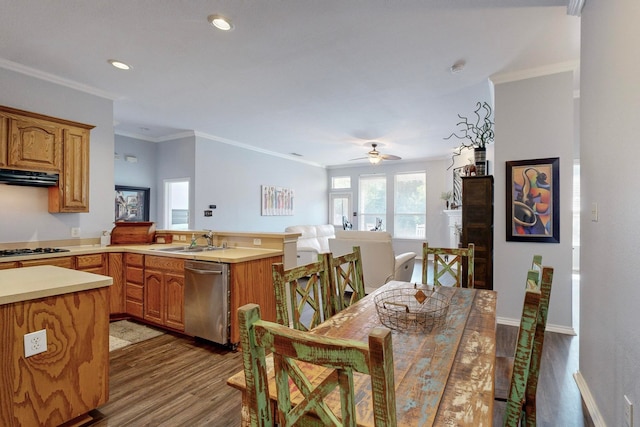 dining space with wood-type flooring, ornamental molding, sink, and ceiling fan