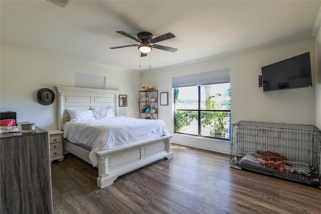 bedroom with ceiling fan, ornamental molding, and dark hardwood / wood-style flooring