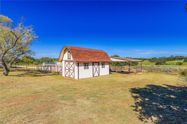 view of outbuilding featuring a lawn and a rural view