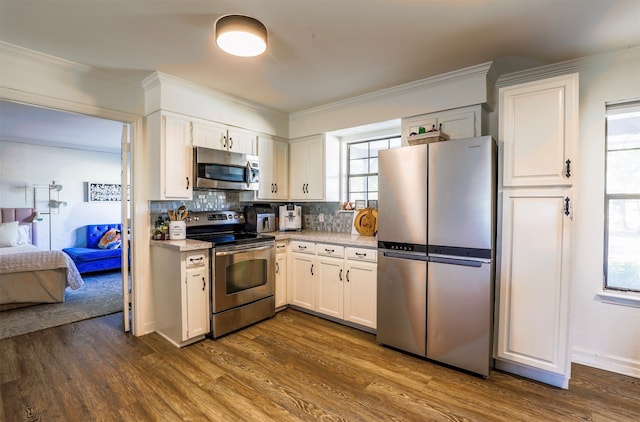 kitchen featuring white cabinetry, appliances with stainless steel finishes, dark hardwood / wood-style floors, and tasteful backsplash