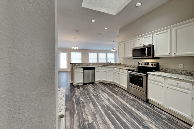 kitchen with appliances with stainless steel finishes, dark wood-type flooring, sink, decorative light fixtures, and white cabinets