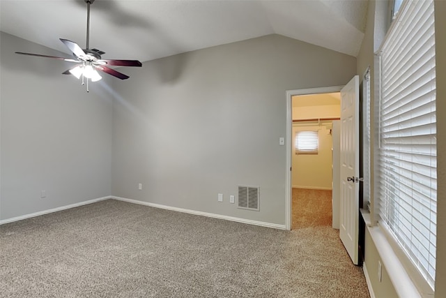 carpeted empty room with ceiling fan and vaulted ceiling