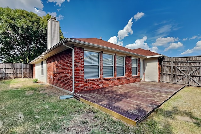 back of property featuring a lawn and a deck